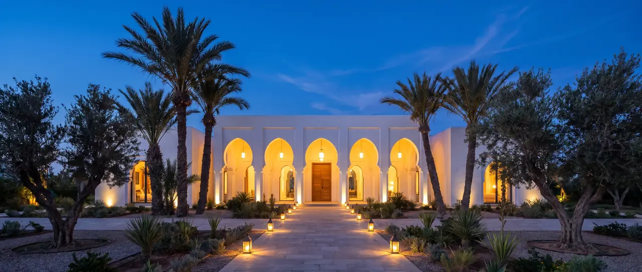 Villa marocaine à l’heure bleue, arcades éclairées et allée de lanternes